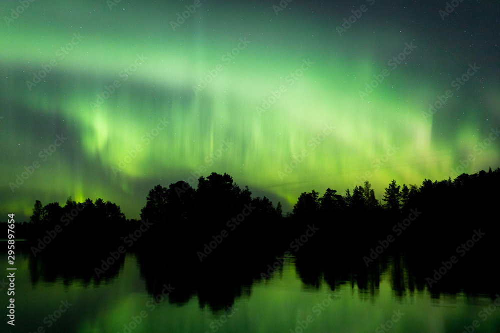 Wall mural northern lights over lake in finland