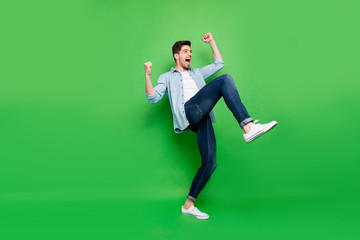 Full length body size turned photo of cheerful positive excited ecstatic man rejoicing with his...
