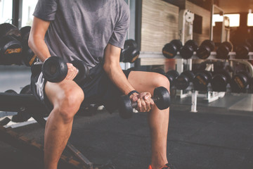 Closeup of a thin man doing exercises with dumbbell. Fitness muscular body. Fitness concept