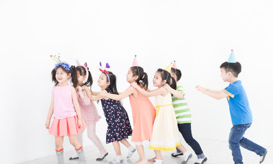 Obraz premium pretty asian children group holding hand on friends shoulder and walk on gray background, they feeling happy in birthday party, they smile and play together, recreation activity