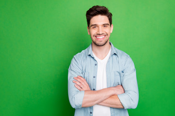 Photo of amazing business guy in excited mood with crossed hands looking forward to start working day wear casual denim shirt isolated over green color background - obrazy, fototapety, plakaty