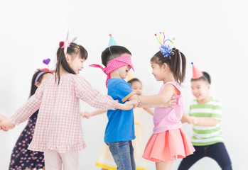 pretty asian children group holding hand and playing on gray background, they feeling happy in birthday party, they smile and play together, Christmas and new years, recreation activity