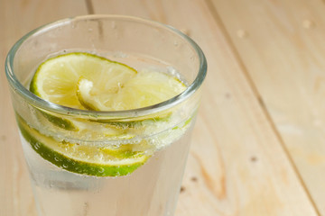 Refreshing glass of fizzy water with lime slices