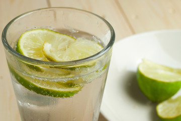 Refreshing glass of fizzy water with lime slices