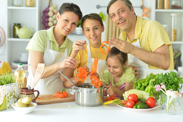 Portrait of family cooking together in kitchen