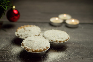 Mince pies dusted with icing sugar on Christmas background