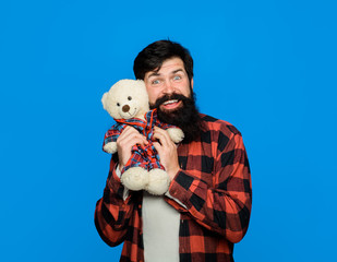 Teddy bear. Man in plaid shirt hold Teddy bear. Bearded man with plush toy. Birthday or anniversary and holiday celebration. Guy with teddy bear. Gift and present concept. Bearded man with teddy bear.