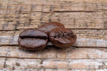Grains of coffee on a wooden background.