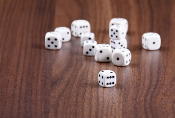 Playing dice stock images. White dice on a wooden background. Playing dice on the table. Playing white dice on a wooden background with copy space for text
