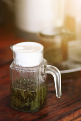 Hot Green tea leaves are boiled in a glass jar.