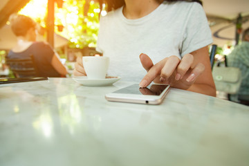 Obraz na płótnie Canvas woman hand phone with coffee in cafe