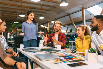 Group of designers discussing affairs, working in modern office