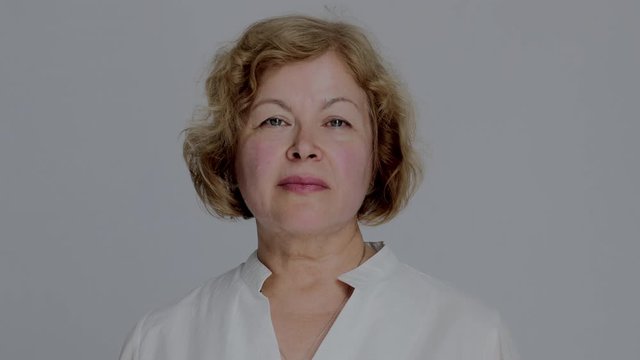 Portrait of the Senior Caucasian Woman Looking Straight to the Camera and Smiling. Confident and Serious Woman Closeup