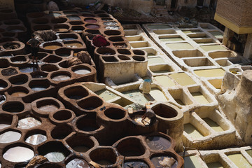 men working in tanneries treating leather on a sunny day