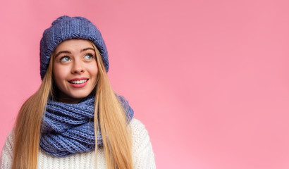 Excited blonde girl in winter set looking at free space