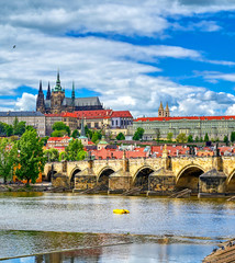 A view across the Charles Bridge and the Vltava River to Prague Castle and St. Vitas Cathedral in Prague, Czech Republic.