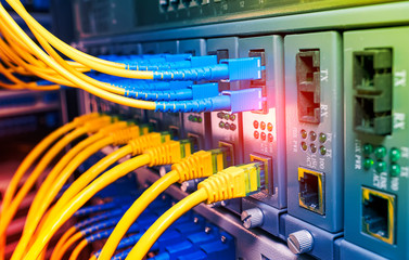 Fiber Optic cables connected to optic ports and UTP, Network cables connected to ethernet ports.