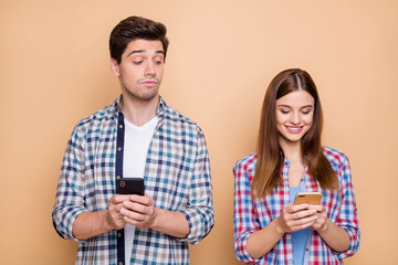 Hmm interesting.... Portrait of pensive guy use his smartphone watch who secret admirer his wife chatting on social network account wear checkered shirt isolated over beige color background