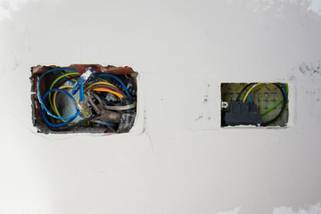 White wall with exposed electric wires