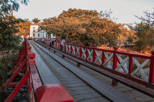 Pirenópolis, Goiás, Brazil, October 17, 2019: The Carmo Bridge, painted in red and white over the Rio das Almas, famous and historic bridge for cars and pedestrians that connects to the city center.
