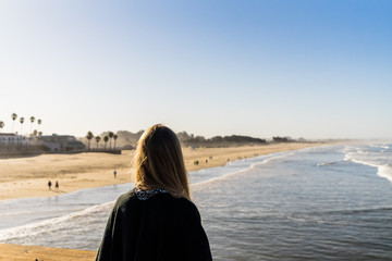 Young woman looking over the ocean on the Coast of California
