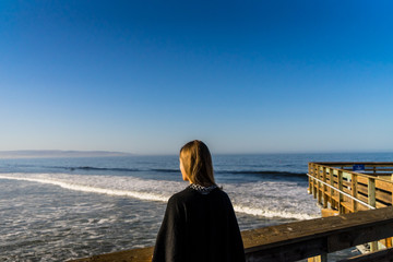 Beautiful girl looking over the pacific ocean in California