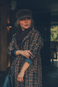 Elder adult caucasian woman on a walk in european street. Autumn retro outfit. Vintage styled and toned image with grain as film imitation