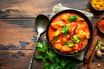 Chicken tikka masala - traditional dish of indian cuisine in a clay bowl . - obrazy, fototapety, plakaty