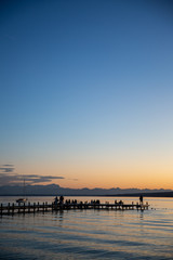 Steg in Percha am Starnberger See am Abend mit Bergblick