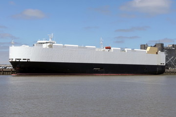 schwarz weisser Autotransporter im Hafen