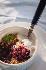 baked oat-blueberry crumble with mint in a white and blue plate on a rustic linen tablecloth. Save...