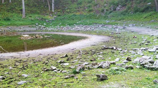 Dried up meteorite Kaali Crater in Estonia green paradise landscape, panning shot 