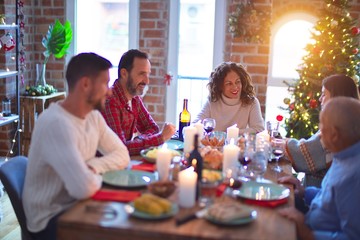 Beautiful family smiling happy and confident. Eating roasted turkey celebrating Christmas at home