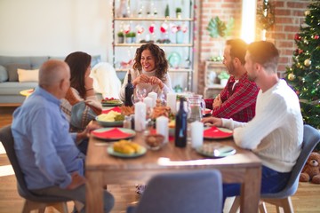 Beautiful family smiling happy and confident. Eating roasted turkey celebrating Christmas at home