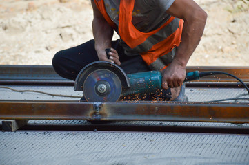 Worker grinds welded rail joint