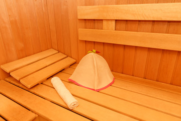 Wooden empty sauna room interior as background. towel and hat for the sauna