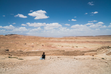 Fototapeta na wymiar Two caucasian european white traveler girls standing on top of a cliff spreading arms over a desert land in Morocco