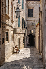 Fototapeta na wymiar Narrow stone street with stone houses, facade and lanterns in Dubrovnik city, Dalmatia, Croatia, popular touristic destination