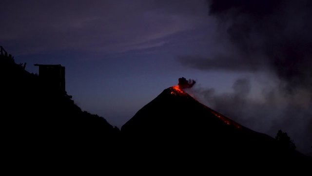 Beautiful Guatemala volcano Acatenango and volcano Fuego 4K video. Landscape panorama view of Fuego volcano erupting lava, fire and smoke at night. Famous turistic destination near Antiqua.