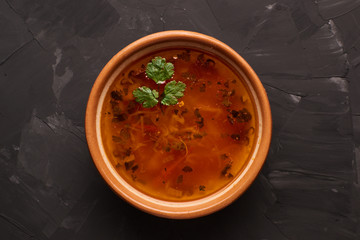 Bowl of traditional soup Borscht on black table