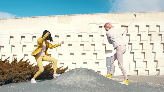 Two fashionable woman golfing with a real egg