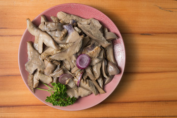 Fried mushrooms on a lilac plate stands on a beautiful wooden background