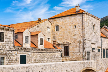 Stone houses with red roofs; old city stone walls, Dubrovnik, Dalmatia, Croatia,  blue summer sky, the most popular touristic travel destination  