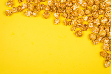 Caramel pop corn on yellow background. Copy space.