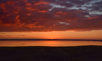 Naklejka na ściany i meble Beautiful serene colored sunset over Burtnieku lake and lake reflections of the sky above, Latvia 