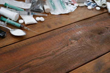 A lot of narcotic substances and devices for the preparation of drugs lie on an old wooden table
