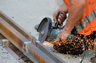 Worker grinds welded rail joint