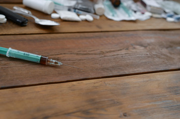 A lot of narcotic substances and devices for the preparation of drugs lie on an old wooden table