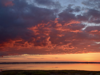 Beautiful serene colored sunset over Burtnieku lake  and lake reflections of the sky above, Latvia 