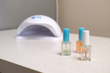 UV diode lamp lights for nails and set of cosmetic nail polish for manicure and pedicure on white...